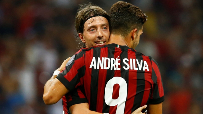 Gelandang AC Milan, Riccardo Montolivo memeluk rekan setimnya, Andre Silva