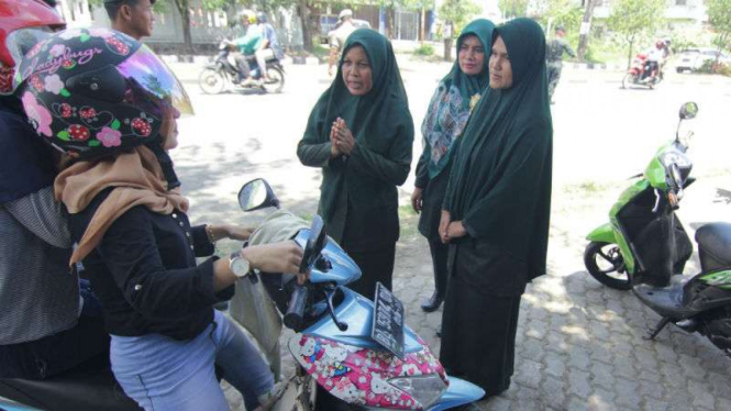 Perempuan pengendara sepeda potor berpakaian ketat dirazia oleh Polisi Syariat Islam, di Jalan Teuku Nyak Arif, Banda Aceh, Aceh, pada Kamis, 24 Agustus 2017.