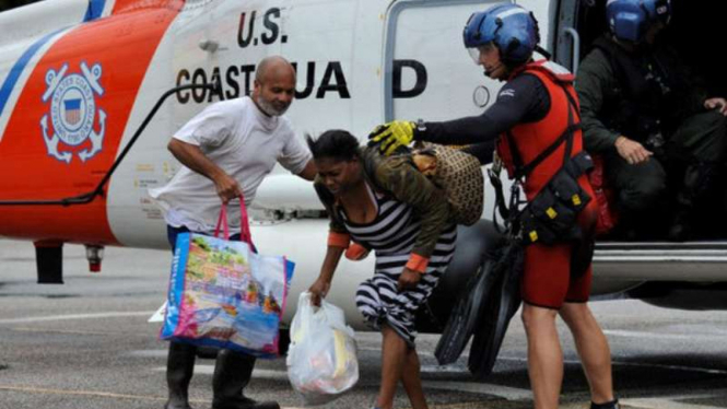 Petugas SAR mengevakuasi pasangan suami istri dari terjangan badai Harvey di AS.