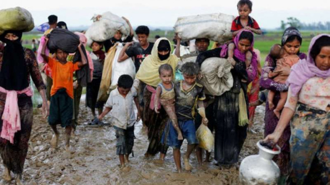 Warga Rohingya mengungsi dari desa mereka yang dibakar aparat.