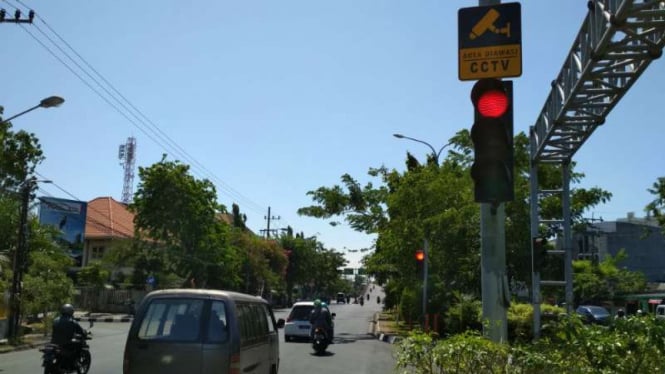 Traffic Light di Surabaya dengan papan informasi pengawasan CCTV.