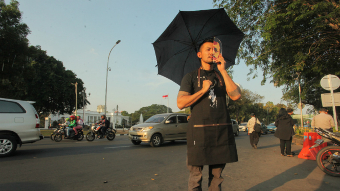 Aktor Rio Dewanto menggunakan topeng aktivis HAM Munir saat melakukan aksi Kamisan ke-505 di seberang Istana Merdeka, Jakarta, Kamis (7/9/2017). 