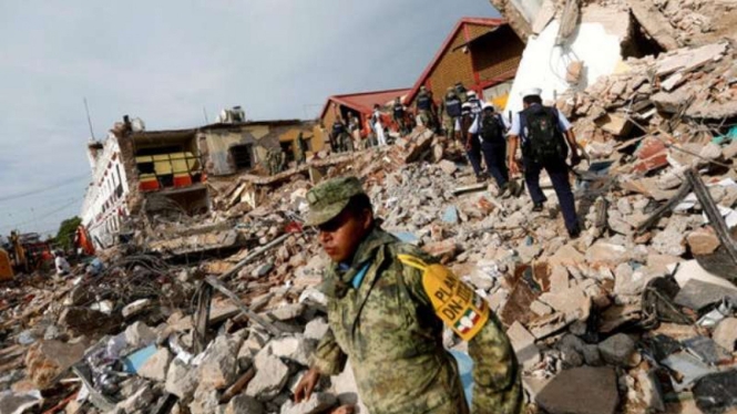 Petugas d iantara bangunan yang runtuh akibat gempa di Meksiko.