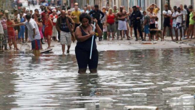 Seorang perempuan melintasi area yang banjir setelah diterjang badai Irma.