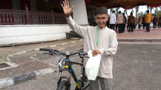 Abubakar dengan hadiah sepeda dari Presiden Jokowi.