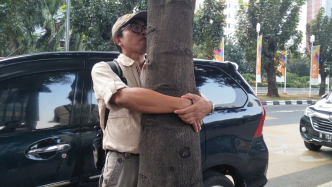 Aksi memeluk pohon Koalisi Pejalan Kaki dan Thamrin School di Sudirman, Jakarta.