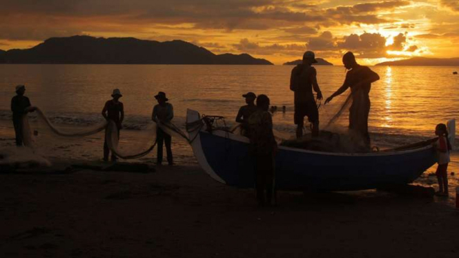 Nelayan menarik jala di sore hari di Pantai Gampong Jawa, Banda Aceh