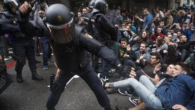 Polisi Spanyol pukuli peserta jajak pendapat Catalan di Barcelona.