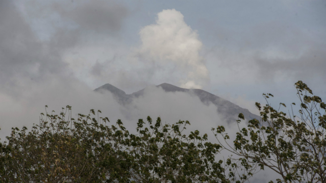 Asap putih menyembur dari kawah Gunung Agung yang saat ini masih level awas terlihat dari Desa Datah, Karangasem, Bali, Minggu (8/10). 