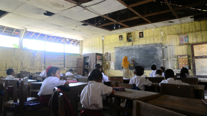 Sejumlah murid belajar di dalam kelas yang plafonnya rusak di SD 5 Sembungharjo, Pulokulon, Grobogan, Jawa Tengah, Senin (9/10/2017). 