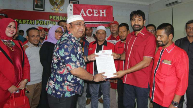 Ketua Umum Partai Aceh, Muzakir Manaf (kedua dari kanan), menyerahkan berkas pendaftaran partainya kepada Ketua KIP Aceh, Ridwan Hadi, di Banda Aceh pada Senin malam, 16 Oktober 2017.