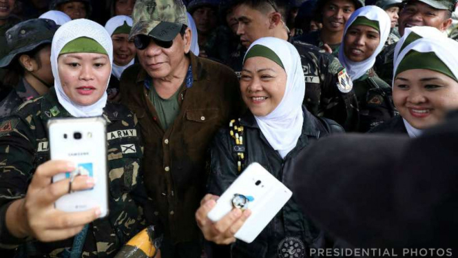 Presiden Filipina, Rodrigo Duterte, dengan para tentara wanita di Marawi.