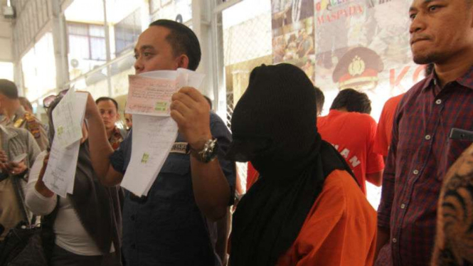 Polisi menunjukkan tersangka dan barang bukti penipuan bermodus seleksi calon pegawai negeri sipil di Markas Polresta Banda Aceh, Aceh, pada Kamis, 19 Oktober 2017.