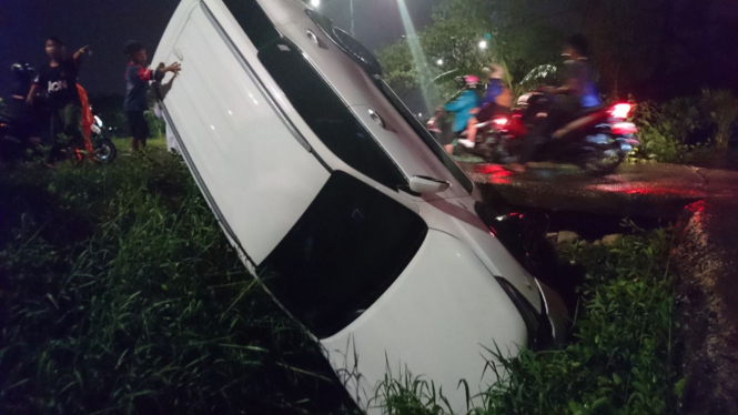 Sebuah mobil Toyota Fortuner berwarna putih terperosok di Jalan Inspeksi Kanal Banjir Timur, Pondok Kopi, Jakarta Timur, pada Kamis petang, 19 Oktober 2017.