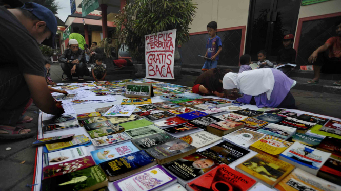 Warga melihat buku koleksi relawan Perpustakaan Terbuka yang dijejerkan di halaman Mesjid Agung Atsauroh di Serang, Banten