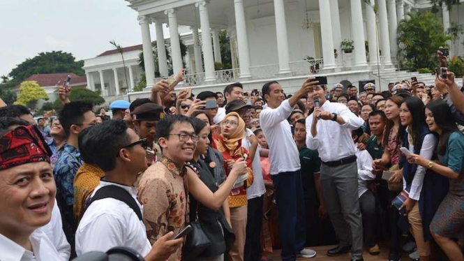 Presiden Joko Widodo (tengah) berswafoto dengan peserta saat peringatan Hari Sumpah Pemuda ke-89 di Halaman Istana Bogor.