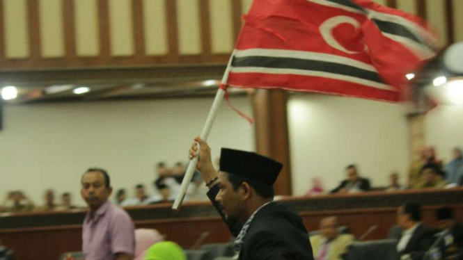Anggota Dewan Aceh mengibarkan bendera bulan bintang dalam rapat paripurna di gedung DPR Aceh pada Selasa, 31 Oktober 2017.