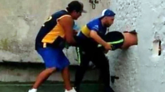 Potongan gambar suporter Boca Juniors terjepit di tembok stadion.