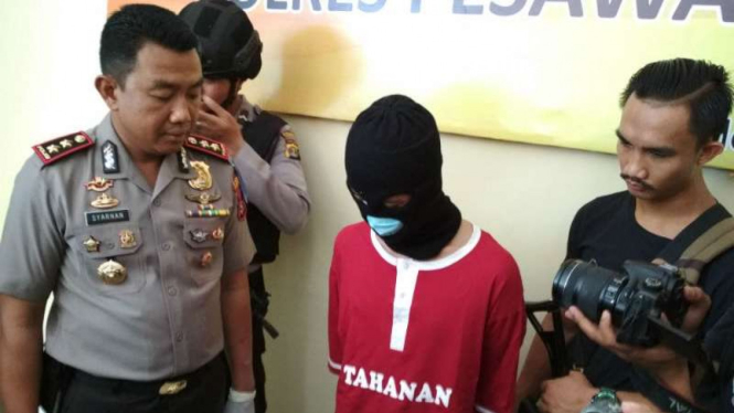 Polisi memperlihatkan Endi Oktriawan, seorang guru tersangka pencabulan murid-muridnya, di Markas Polres Pesawaran, Lampung, pada Rabu, 8 November 2017.