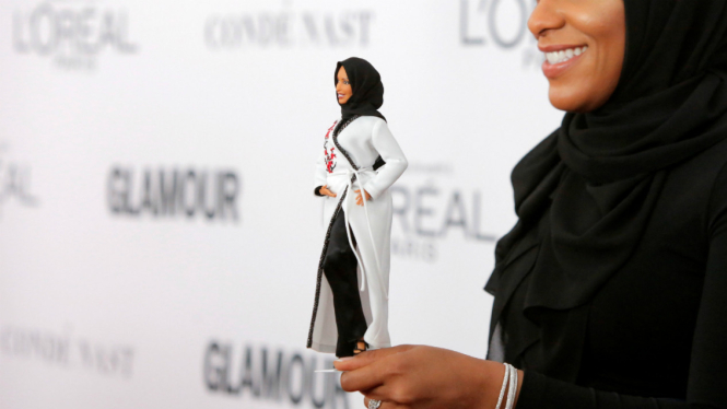 Ibtihaj Muhammad memegang Barbie berhijab
