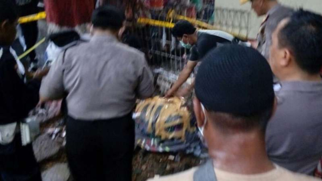 Polisi memeriksa mayat pria dalam karung di Terminal Kampung Rambutan.