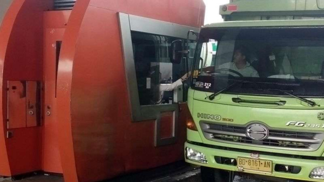 Pengemudi truk mengambil tiket di pintu tol Merak.