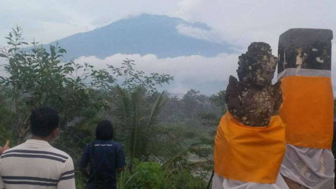 Warga menyaksikan Gunung Agung dari kejauhan di Kabupaten Karangasem, Bali, pada Kamis, 23 November 2017.