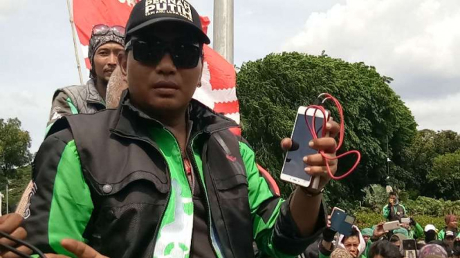 Andreas, pengemudi gojek online saat unjuk rasa di depan Istana Merdeka, Jakarta.