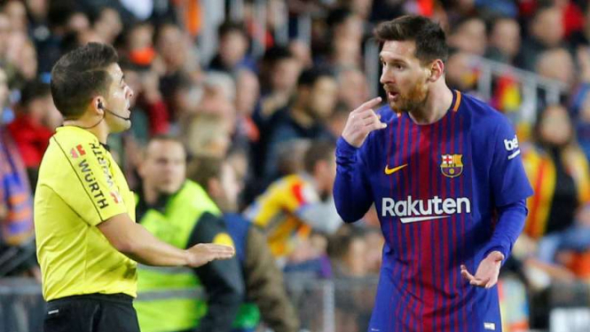 Striker Barcelona, Lionel Messi (kanan) memprotes asisten wasit