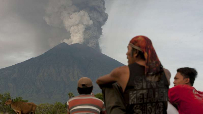 Sejumlah warga menyaksikan kepulan asap dan abu vulkanik yang menyembur dari kawah Gunung Agung di Desa Datah, Karangasem, Bali, Senin (27/11/2017).