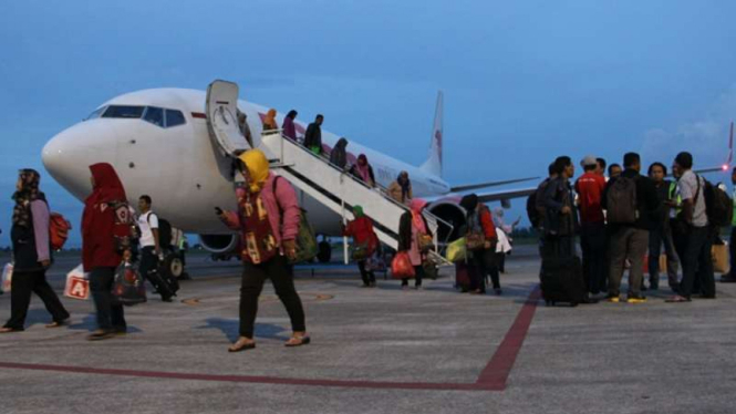 Sejumlah penumpang turun dari pesawat Lion Air setelah gagal berangkat ke Surabaya setelah penutupan Bandara Internasional Lombok, Minggu (26/11). 