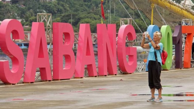 Seorang turis asing memotret kapal yang bersandar di pelabuhan CT 3 BPKS Sabang