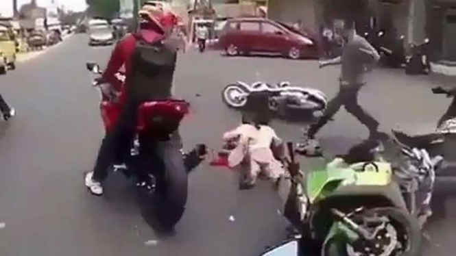 Pengendara wanita jatuh akibat tersenggol motor gede.