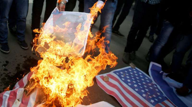 Aksi bakar bendera AS oleh demonstran Palestina atas klaim Yerusalem di Gaza