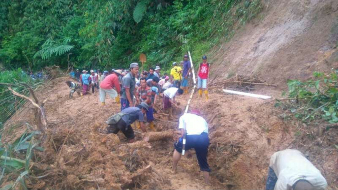 Sejumlah warga di Kabupaten Ogan Komering Ulu Sumatera Selatan bergotong royong membersihkan material longsor yang menutupi jalan desa, Jumat (8/12/2017)