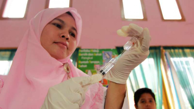 Petugas kesehatan bersiap menyuntikkan vaksin DPT (fifteri, pertusis, dan tetanus) di Posyandu Bungong Jaroe, Kampung Mulia, Banda Aceh, Aceh, pada Selasa, 12 Desember 2017.
