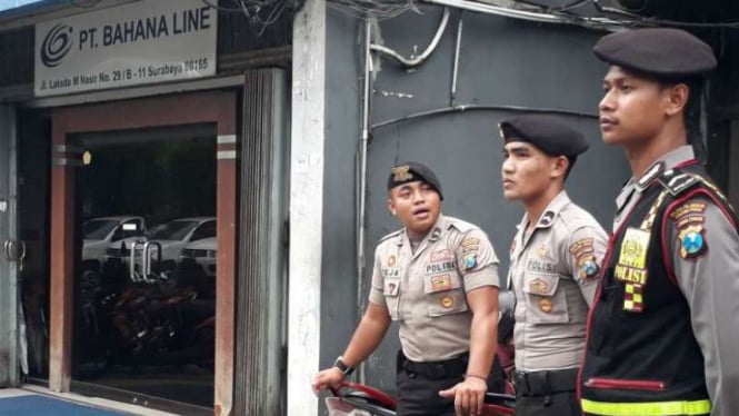 Polisi berjaga di halaman kantor perusahaan PT Bahana Line, lokasi ledakan paket handphone, di kawasan Tanjung Perak Surabaya, Jawa Timur, pada Kamis, 15 Desember 2017.