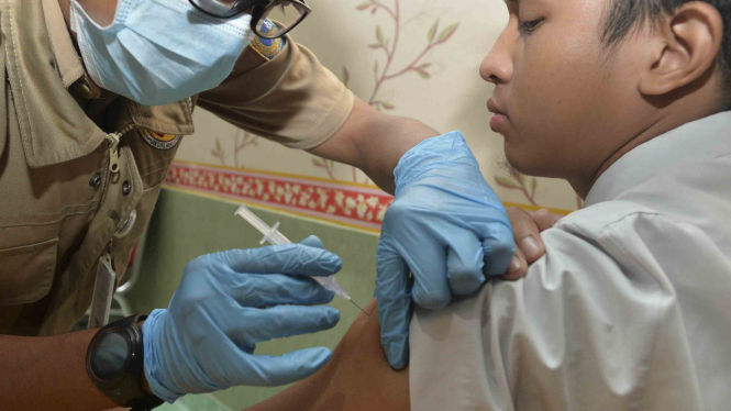 Seorang siswa SMA Negeri 33 mendapatkan imunisasi serentak atau Outbreak Response Immunization (ORI) Difteri, di Cengkareng, Jakarta.