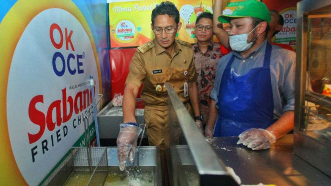 Wakil Gubernur DKI, Sandiaga Uno ikut menggoreng ayam saat meresmikan stan OK OC