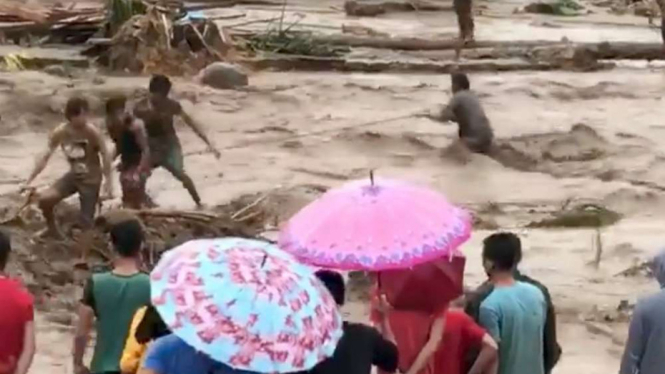 Orang-orang membantu menyelamatkan korban banjir di Lanao Del Norte, Filipina.