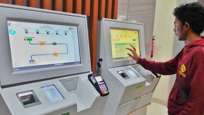 Seorang warga menjajal mesin pemesan tiket kereta khusus jalur bandara di Bandara Soekarno-Hatta, Tangerang, Banten, pada Selasa, 26 Desember 2017.