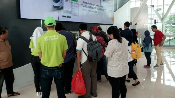 Calon penumpang kereta Bandara Soekarno-Hatta mengantre di mesin pencetak tiket sebelum masuk ke stasiun pada Rabu, 27 Desember 2017.