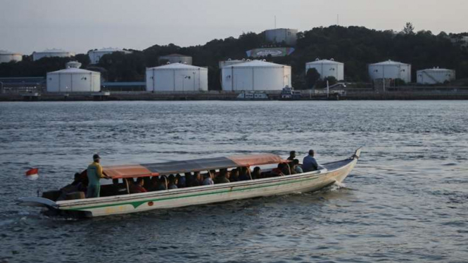 Perahu motor melintas Terminal Bahan Bakar Minyak Pulau Sambu di Batam.