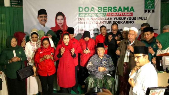Pasangan calon gubernur dan wakil gubernur Jawa Timur, Saifullah Yusuf dan Puti Guntur Soekarno, berdoa bersama pendukung sebelum mendaftar ke KPU di Surabaya pada Rabu malam, 10 Januari 2018.