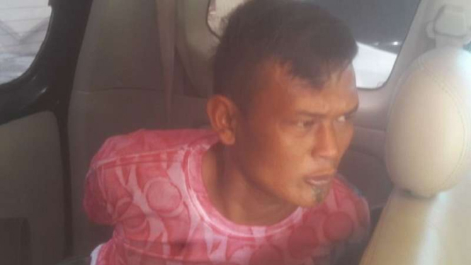 Adi saat dibawa polisi usai diringkus di Jawa Tengah setelah membunuh salah satu istrinya.