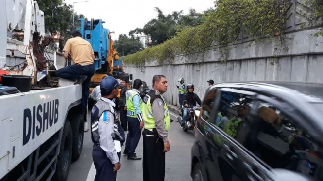 Petugas Dinas Perhubungan DKI Jakarta sedang melakukan evakuasi sebuah mobil crane yang mogok di jalur underpass Senen Jakarta Pusat, Kamis (18/1/2018)