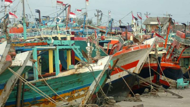 Nelayan berada di samping kapal cantrang saat tidak melaut di Pelabuhan Jongor.