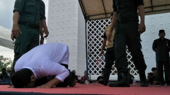 Seorang germo PSK Online bersujud di hadapan ribuan penonton usai dicambuk di halaman Masjid Ulee Kareng, Banda Aceh, Aceh, pada Jumat, 19 Januari 2018.