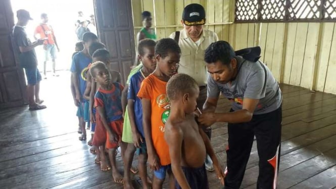 Tim Satgas TNI memberikan imunisasi kepada para anak-anak dari Suku Asmat Papua.