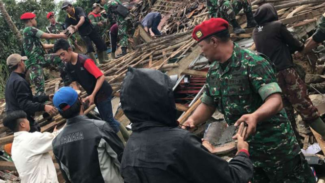 Prajurit Kopassus membantu warga yang terkena bencana di Desa Citalahap, Bogor, Selasa, 23 Januari 2018. 